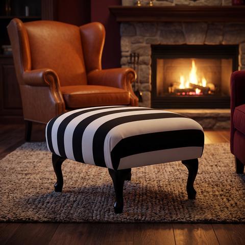 Small footstool with striped fabric in front of a wing chair
