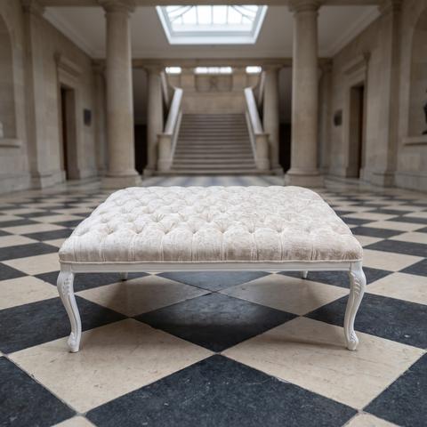 Large stool with light buttoned upholstery in an entrance hall