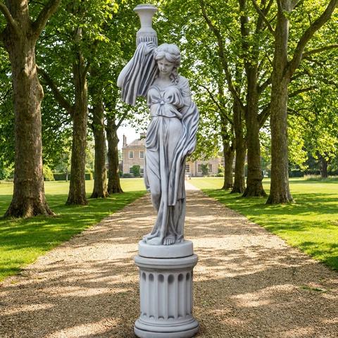 Sculpture sur une colonne de jardin dans une allée d'arbres