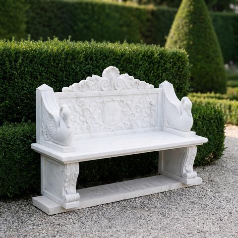 White marble garden bench with carved swans in a formal garden