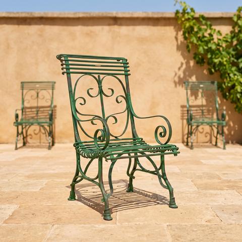 Green wrought iron garden chairs on a terrace