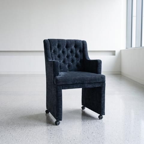 Fauteuil gris bleu foncé capitonné sur roulettes