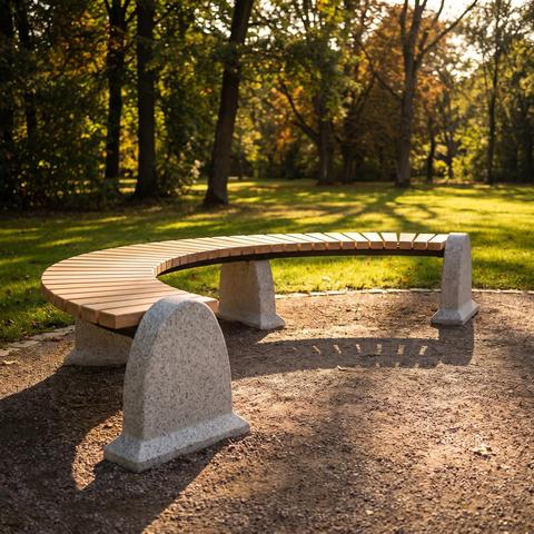 Parkbank mit Steinwangen in einer Baumallee