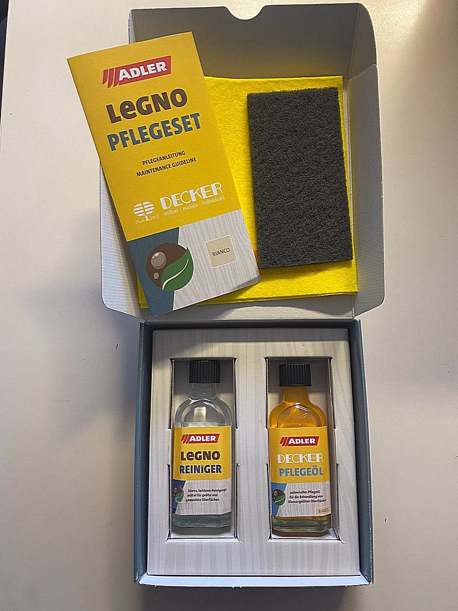 Geöffnetes Möbel-Pflegeset mit zwei Pflegeflaschen in einer gelben Verpackung.