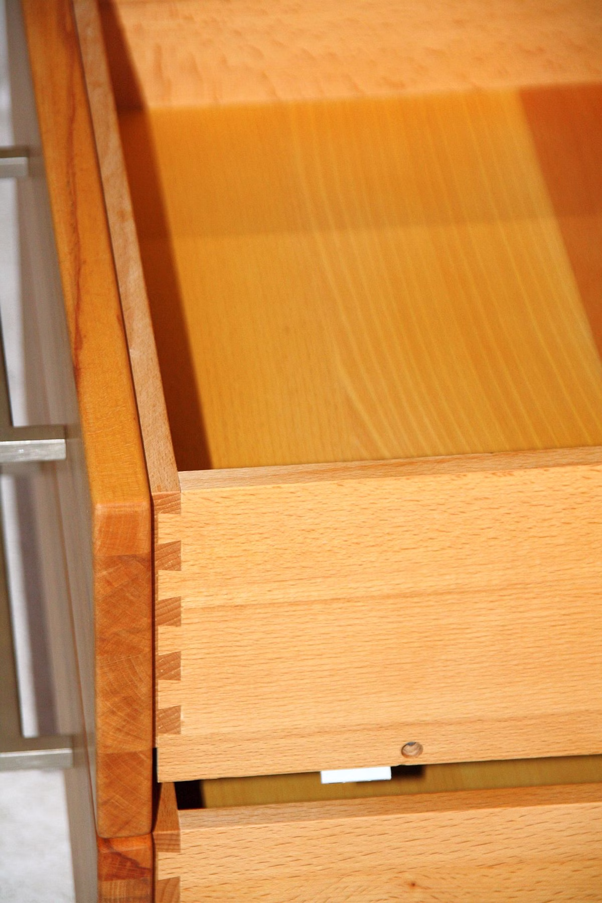 massivholz-highboard-casera-geoeffnet-stauraum. Geöffnetes Casera Vollholz-Highboard mit Blick auf geöffneten Schubladen.