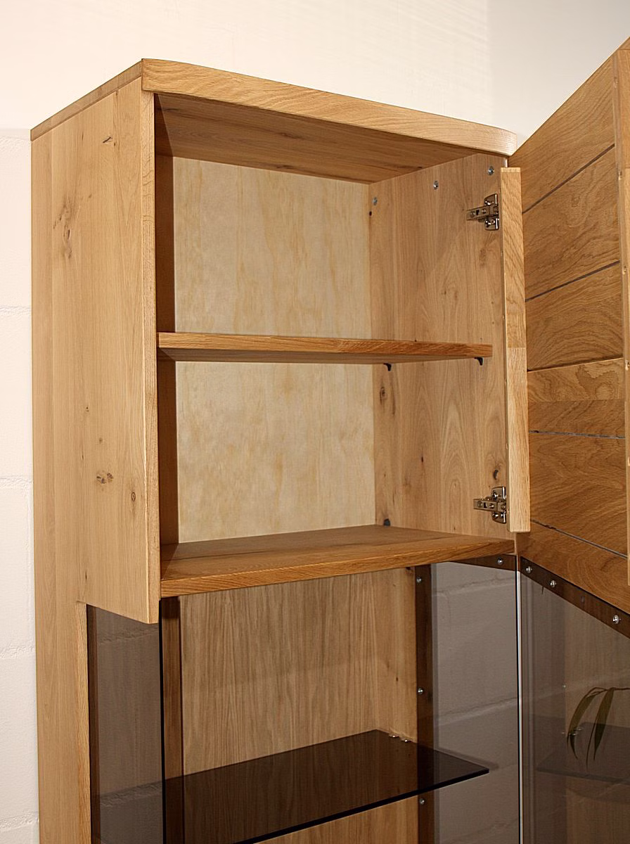 schrankwand-pinos-vitrine-detail . Nahaufnahme der präzise verarbeiteten Kanten und der soliden Eckverbindung der schmalen Pinos Kommode aus Massivholz.