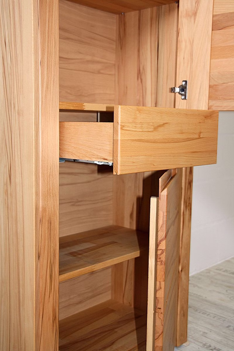 Kleine Schublade im hohen Schrank Herausgezogene kleine Holzschublade in einem hohen Schrank mit sichtbarem Holzinnenraum.