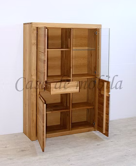 vitrinenschrank-horizont-wildeiche-massiv-natur-geölt Geöffneter Vitrinenschrank aus Massivholz mit sichtbarer Facheinteilung, Glaseinlegeboden und einer leicht ausgezogenen Schublade.