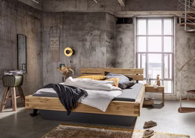 TPT WOODSTOCK 620 Balkenbett aus Wildeiche mit Balkenkopfteil und Sockel-Unterbau im Wohnambiente Balkenbett WOODSTOCK 620 von TPT aus massiver Wildeiche mit Doppelzapfen, Balkenkopfteil und dunklem Sockel-Unterbau im modernen Schlafzimmer