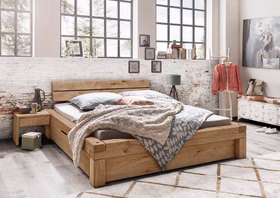 WOODSTOCK I – Schubladenbett Rustikales Holzdoppelbett mit kräftiger Maserung und integrierten unteren Schubladen in einem hellen Schlafzimmer.