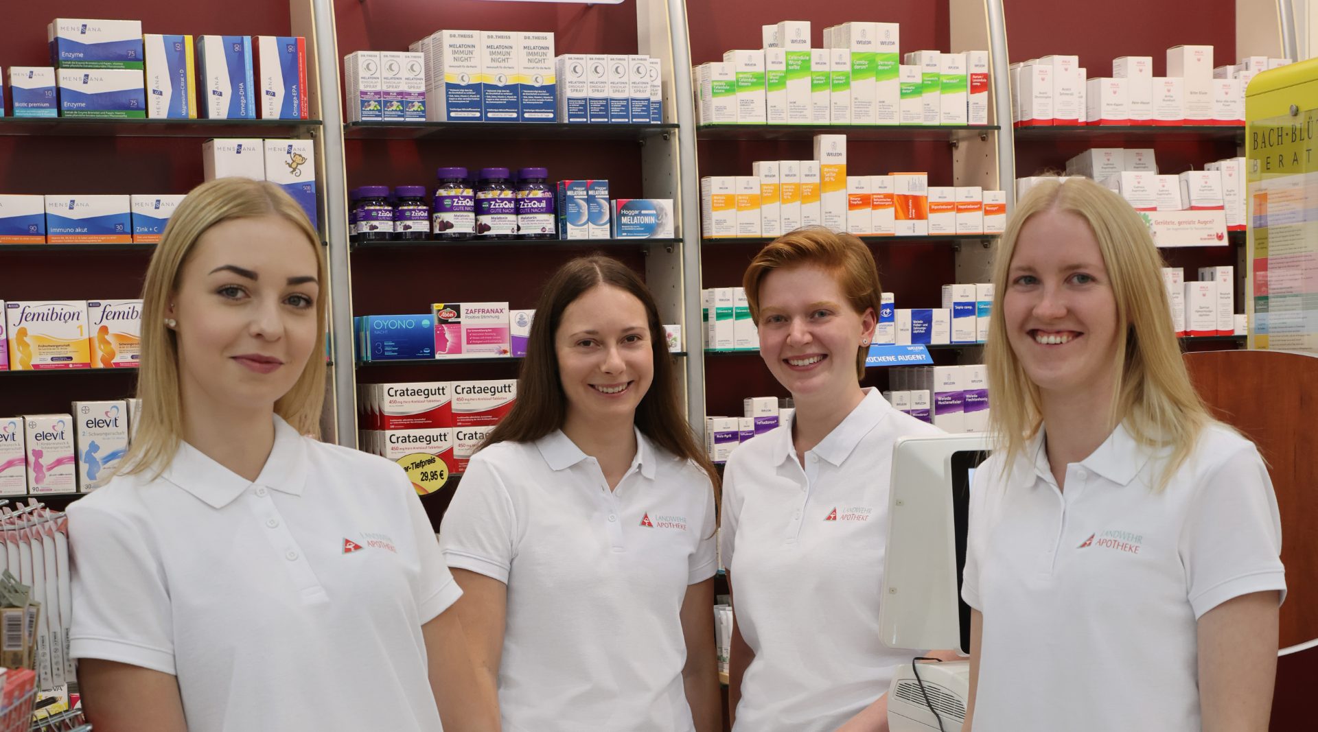 Apotheken-Team in weißen Poloshirts mit aufgedrucktem Logo