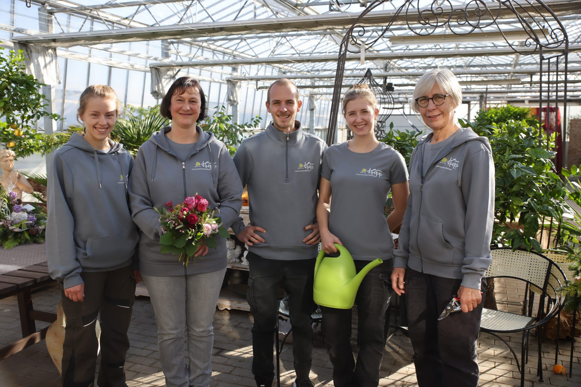 Gärtnerei-Team in einheitlicher Arbeitskleidung mit Logo